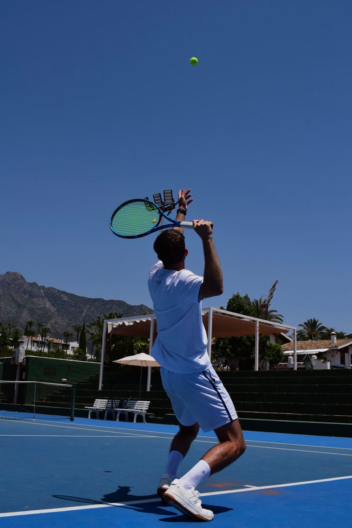 Saque de tenis visto desde el fondo de la pista