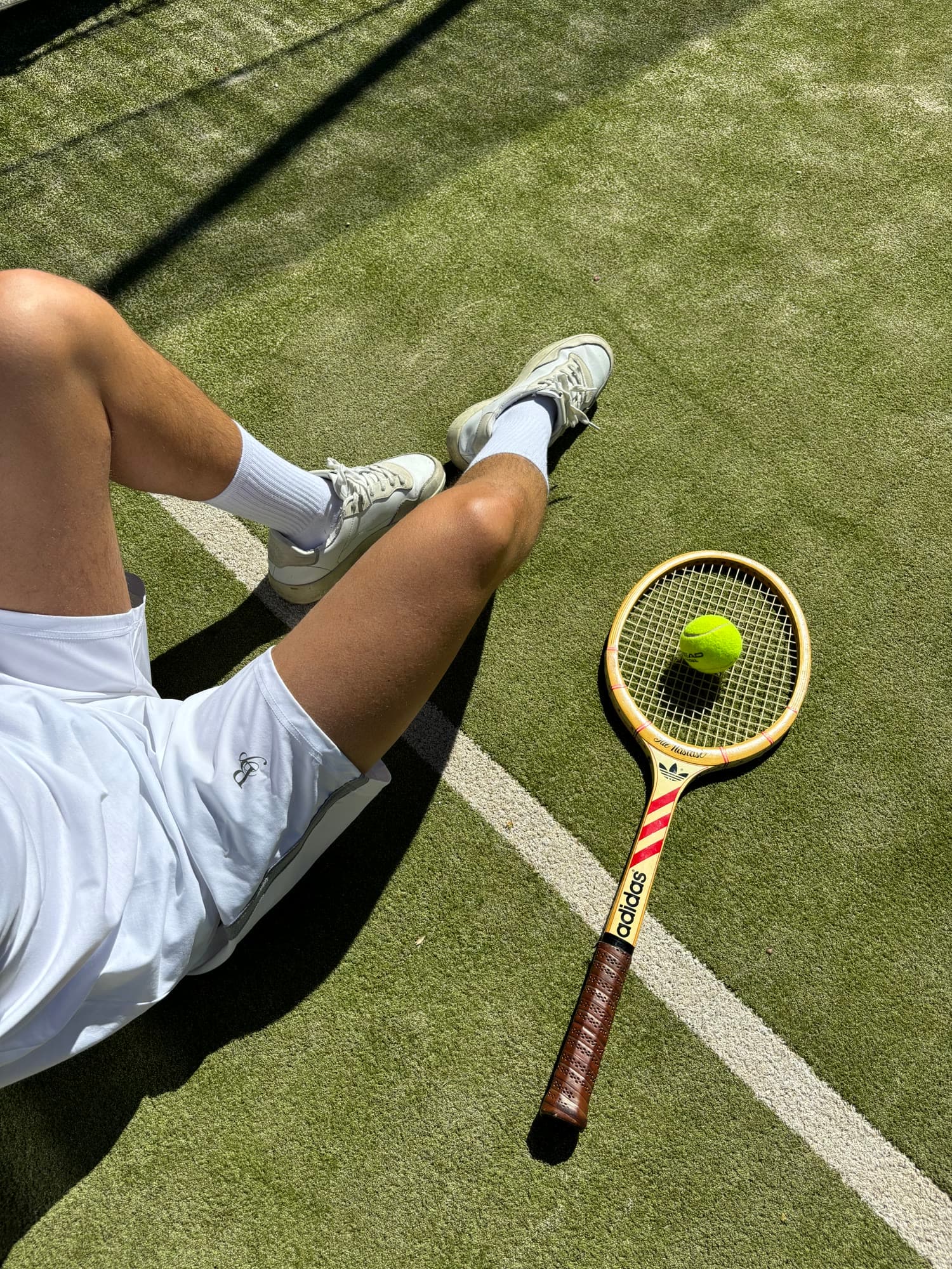 Raqueta de madera y bola sobre césped