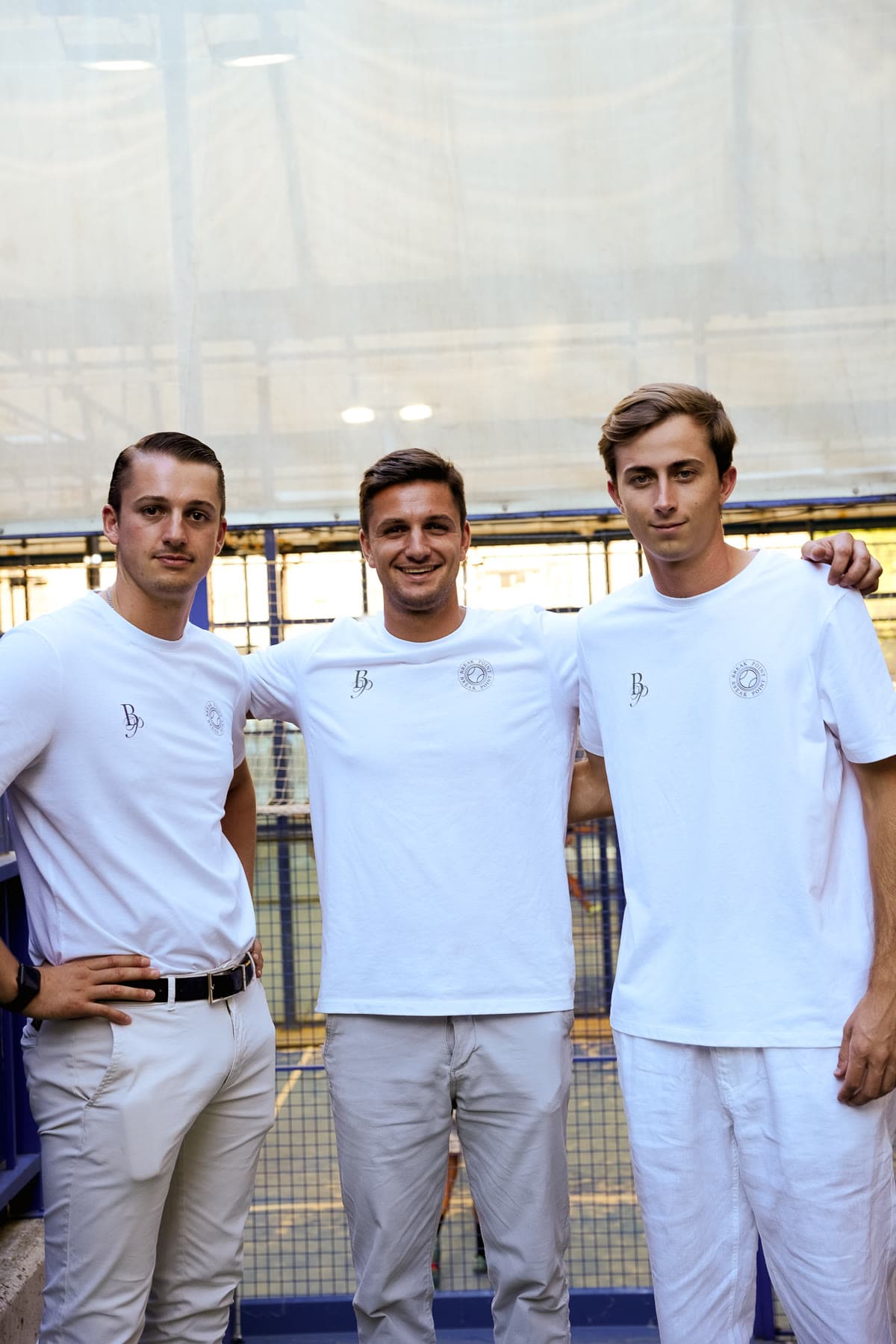 Tres jugadores con camisetas blancas de Break Point en pista cubierta