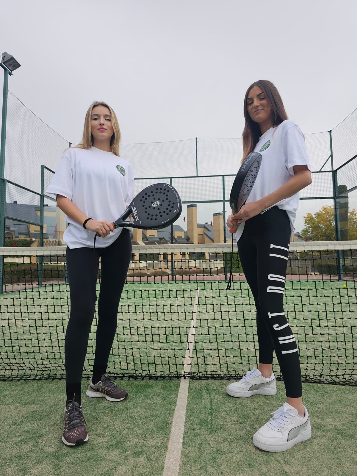 Jugadoras con camisetas Break Point con sello verde en pista de pádel